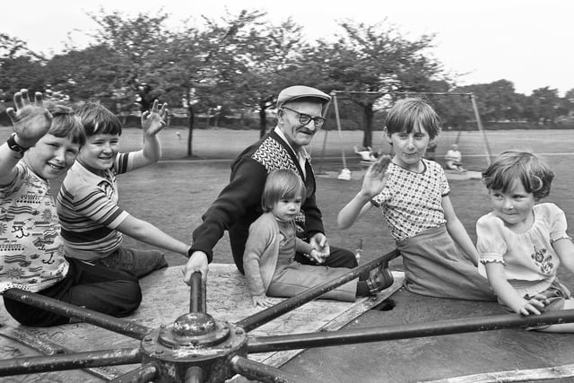 Grandad and youngsters have a twirl on the roundabout at Alexandra Park in 1978