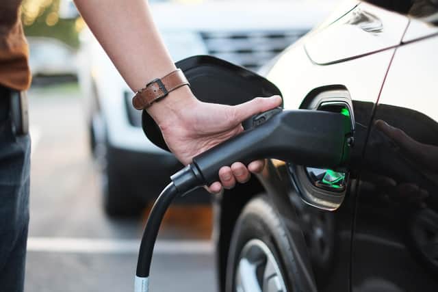 A man at the power supply for electric car charging station.  charging the battery of the vehicle. Picture: Adobe Stock