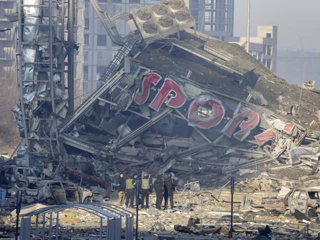 People examine the damage after shelling of a shopping centre, in Kyiv, Ukraine. Eight people were killed in the attack