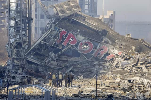 People examine the damage after shelling of a shopping centre, in Kyiv, Ukraine. Eight people were killed in the attack