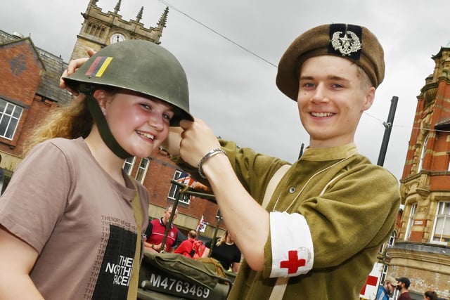 Eliza White, 11, tries on vintage military kit with Dillon Farnworth, right.