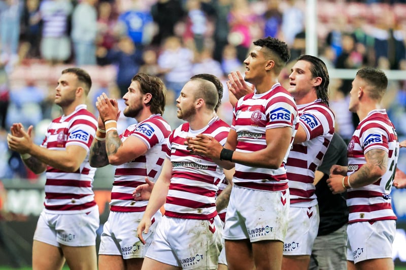 The Wigan players applaud their fans at full time following the win against St Helens.