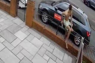 Clambering over the home's fencing, the man can be seen holding the knives in his right hand