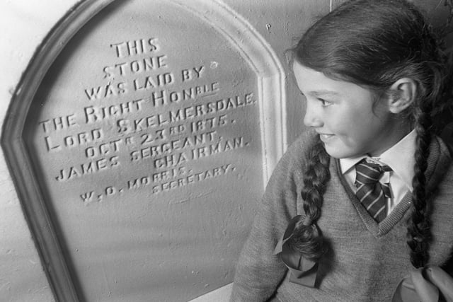Pupil, Ruth Leatherbarrow, looking at the foundation stone at Roby Mill Primary School who were celebrating their centenary on Thursday 23rd of October 1975.