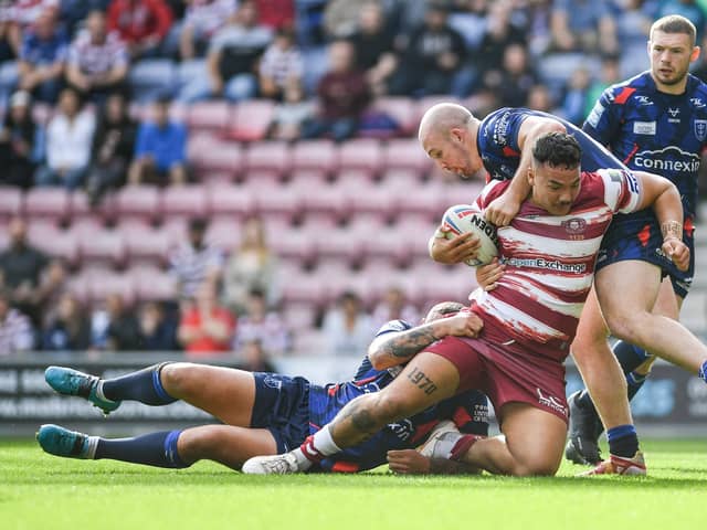 Tyler Dupree of Wigan Warriors held up by George King of Hull KR during the Super League semi-final