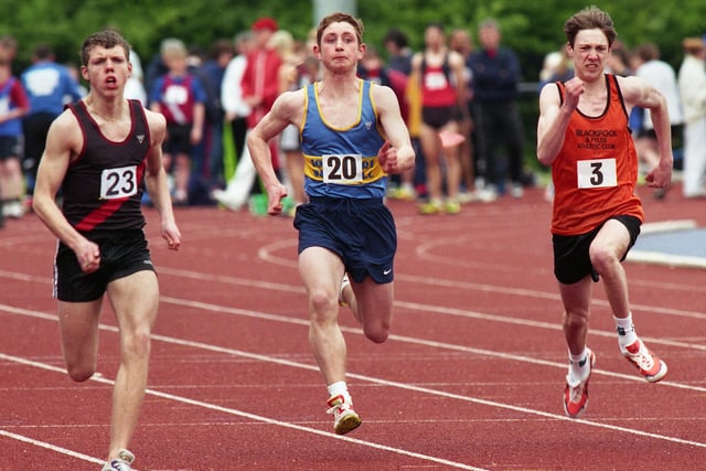 Wigan Harriers' Neil Martin, (left), on his way to winning his heat of the Under 17s men's 100 metres in the first Mid-Lancs League meeting of the season at the Robin Park Arena on Saturday 17th of April 1999.