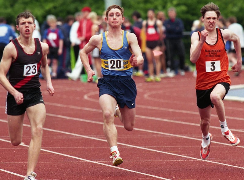 Wigan Harriers' Neil Martin, (left), on his way to winning his heat of the Under 17s men's 100 metres in the first Mid-Lancs League meeting of the season at the Robin Park Arena on Saturday 17th of April 1999.