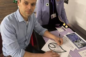 MP Josh Simons for Makerfield, Wigan signing Candle Flame at the White Rose Exhibition at Leigh Spinners Mill with Jean Hensey-Reynard Exhibition Organiser