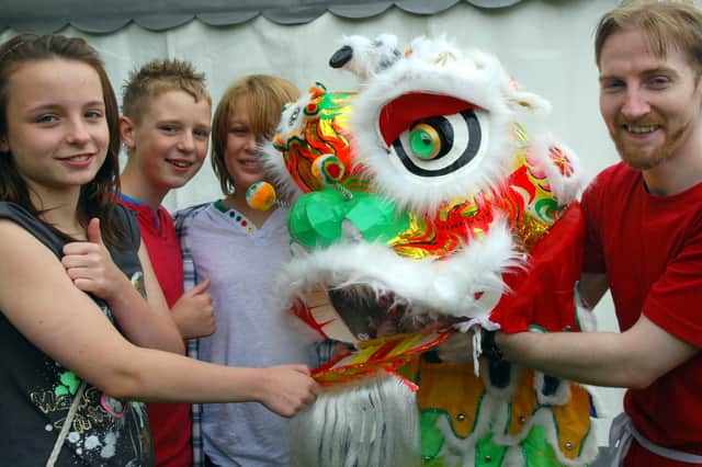 Wigan's annual WOW Festival staged at Alexandra Park in Newtown Wigan
Young visitors Jeff Quigley, Corey Matthew  and Hayley Lyons, with Lion dancer Dave Eccles