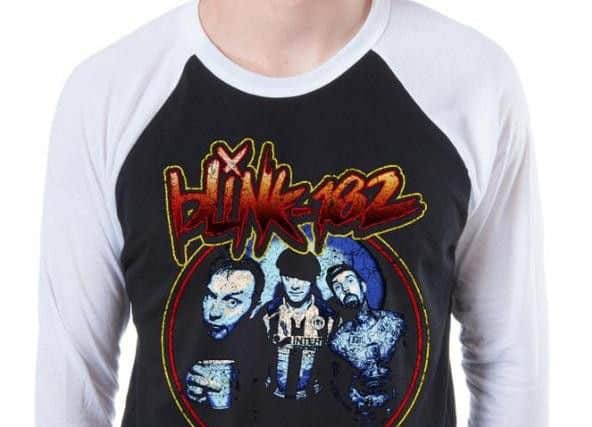 The photo features on an official band t-shirt
