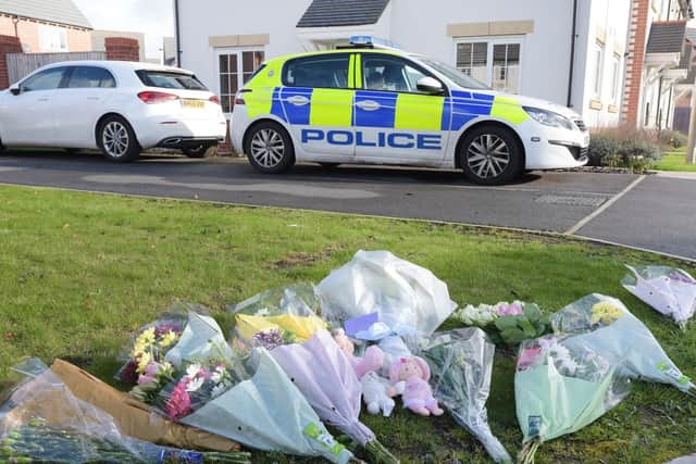 Flowers and police at the home in Fleming Court, Shevington, after police launched a murder inquiry