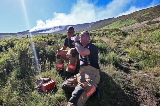 Firefighters take a break from tackling the wildfire