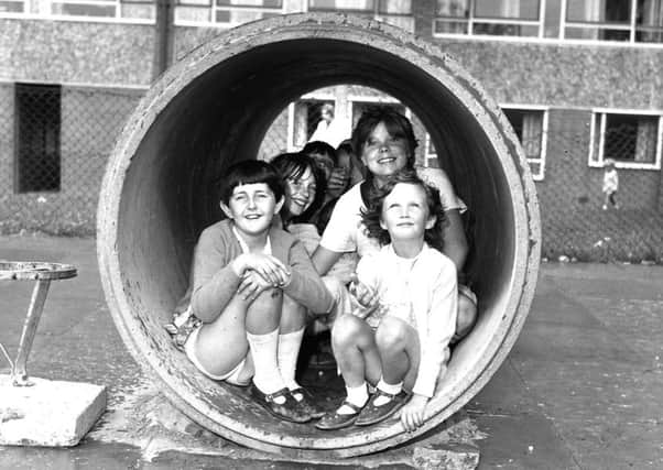 Youngsters shelter from a shower in the playground at Worsley Mesnes housing estate in 1969