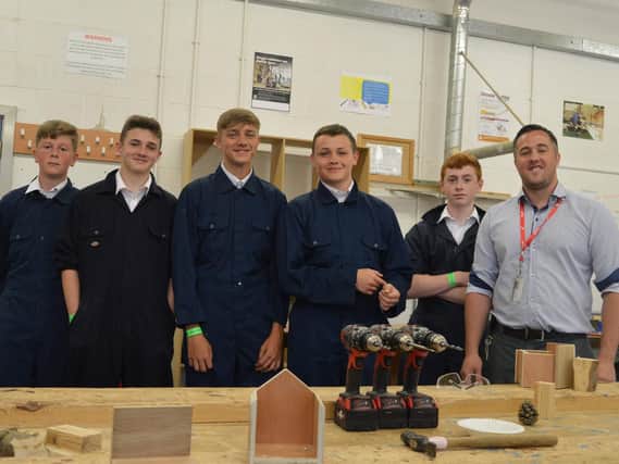 Year 10 school children from Bishop Rawstorne with colleges carpentry and joinery lecturer Gareth Hill.