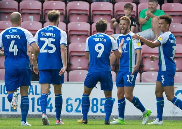 The Latics players congratulate goalscorer Michael Jacobs