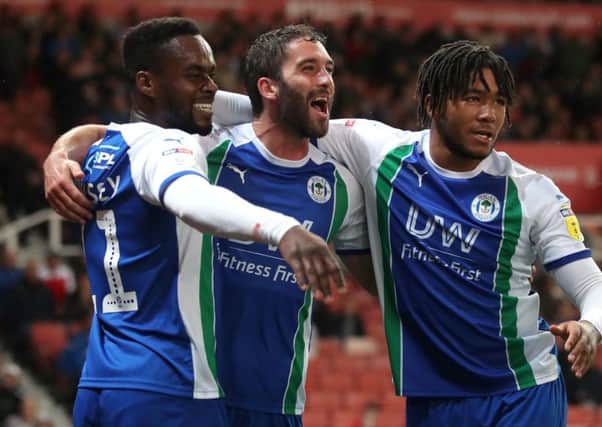Wigan Athletic's Will Grigg (centre) celebrates scoring his side's third goal of the game from the penalty spot with Gavin Massey (left) and Reece James
