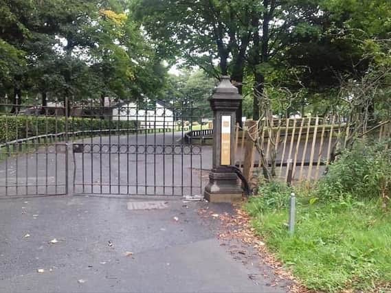 An access point to Haigh Hall blocked by a large gate and picket fencing