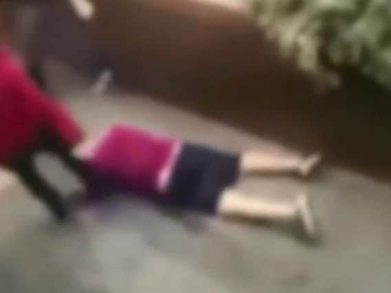 An Aston Villa fan lies unconscious in the street, as he is kicked by a rival fan