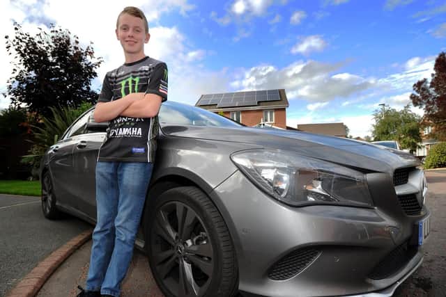 Schoolboy Jack stands proudly by his motor