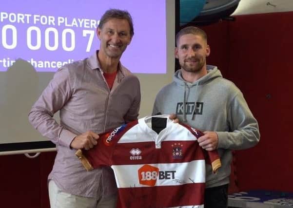 Sam Tomkins presents Tony Adams with a signed Wigan Warriors shirt