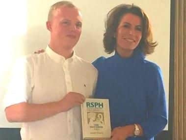 Joseph receives his award from Natasha Kaplinski