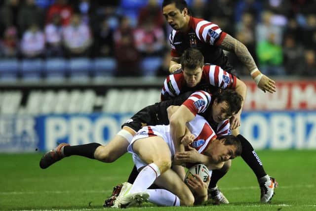 Wigan Warriors' Martin Gleeson and Darrell Goulding (centre) tackle St George Illawarra Dragons' Brett Morris (bottom) during the World Club Challenge match at the DW Stadium