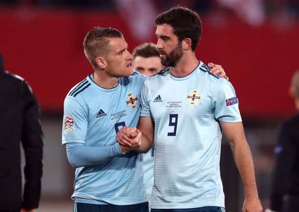Will Grigg is consoled by Northern Ireland captain Steven Davis after the 1-0 defeat in Austria