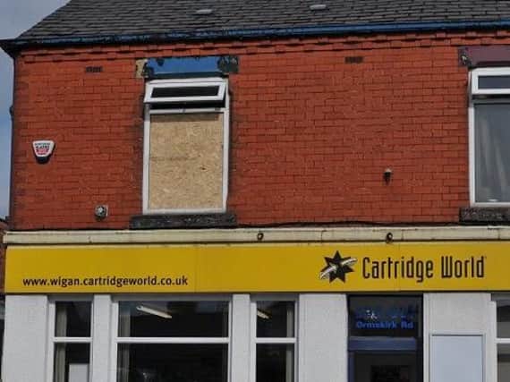 The boarded up window of the flat above Cartridge World