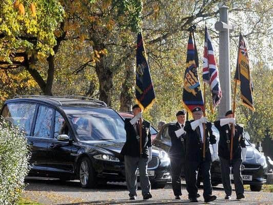 Standard bearers from the Royal British Legion lead the cortege at Wigan Crematorium for veteran Eric Disley