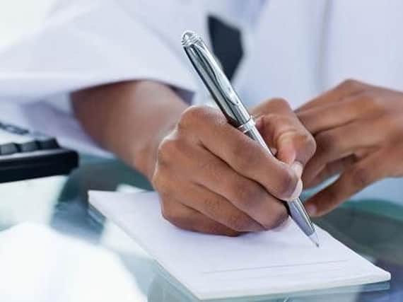 A doctor signing a sick note