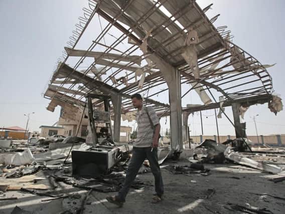 A Yemeni man walks on the rubble of a petrol station after it was hit by Saudi-led airstrikes in Sanaa, Yemen, this year