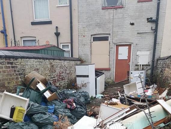 The fly-tipped waste outside the empty home