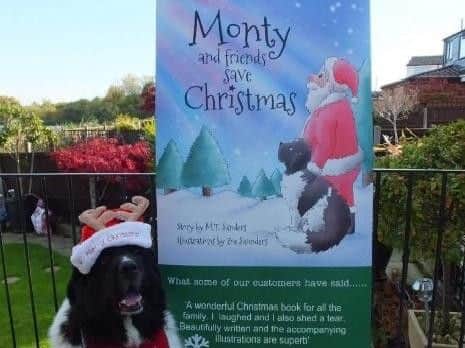 Monty Dogg posing with a sign promoting his first Christmas book