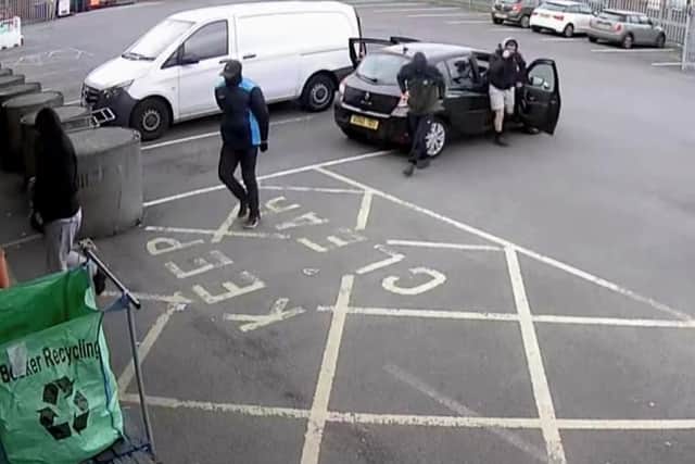 The four men wanted by police outside the cash and carry