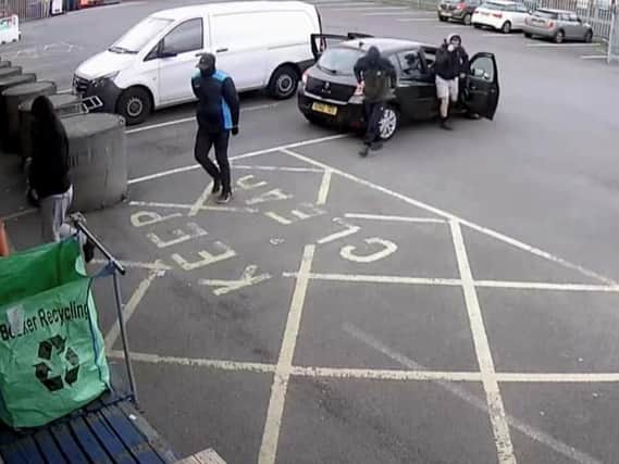The four men wanted by police outside the cash and carry