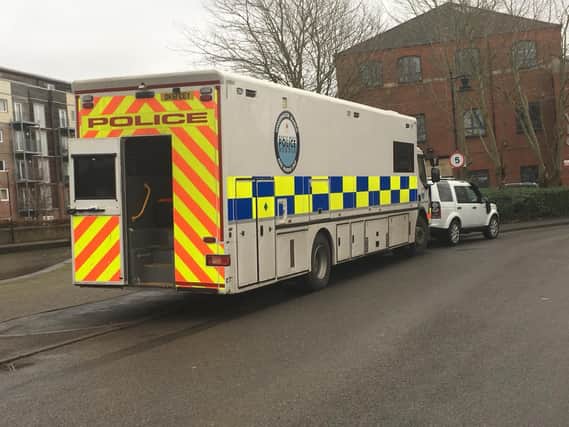 Police vehicles parked next to the canal at Wigan Investment Centre on Friday