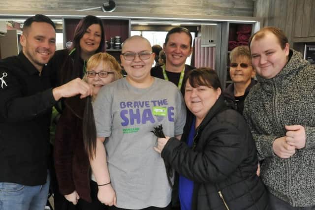 Zeta-Marie Banks, centre, pictured with friends, family and colleagues as she braves the shave to raise funds for Macmillan