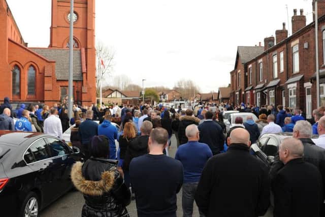 Mourners line the streets outside the church