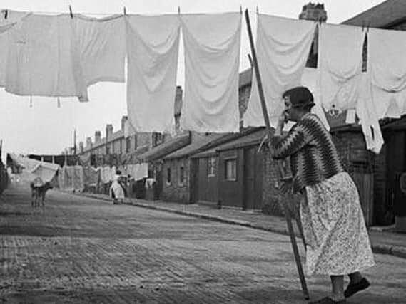 A woman dries her washing in a photograph by Humphrey Spender
