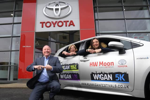 Alex Johnson, from organising charity Joining Jack, with the lead car for Run Wigan Festival, with Dorothy Moon and Steve Mather of HW Moon Official Toyota Centre