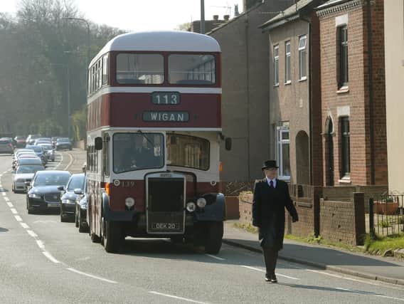 A vintage double decker bus leads the funeral procession along Wigan Road in Standish