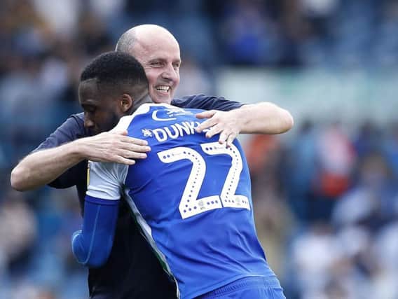 Paul Cook celebrates with Chey Dunkley after Wigans win at Leeds on Good Friday
