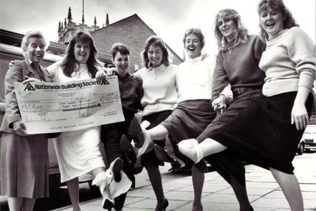Kate Fussell receives a 720 cheque for the ABC appeal from local ladies who took part in a three legged race to raise funds in 1987