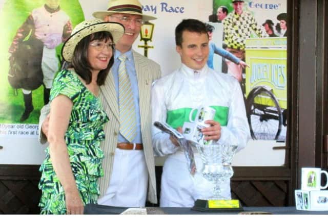 Vivien and Gerry Mawdsley, secretary and president of the George Formby Society, present prizes to jockey William Buick after a previous birthday race at Haydock Park