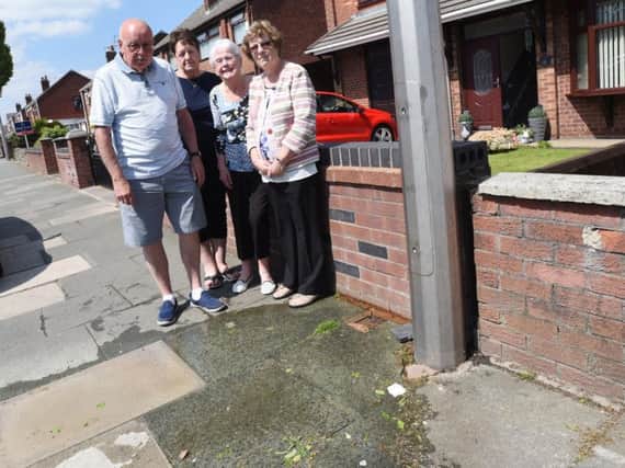 Residents with Coun Billy Rotherham at the site of the water leak