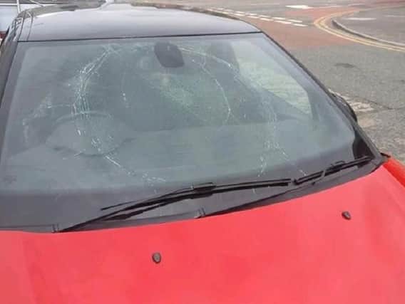 One of the cars with a smashed windscreen