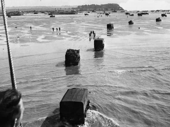 Vehicles and soldiers arriving on the beaches of Normandy