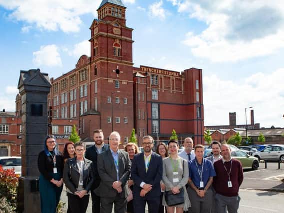 Leader of the council (front row 2nd from left), Councillor David Molyneux, Interact MD (centre, front row), Neil Barber and Wigan Councils director for economy and skills (front row 3rd from right), Becca Heron, outside Trencherfield Mill with Interact employees