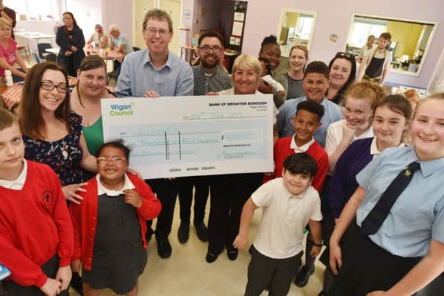 Councillors Paul Kenny and Marie Morgan present a 1,400 cheque to Rev Mark Wade, centre, and members of the Wellspring group which bought a large oven for the kitchen.