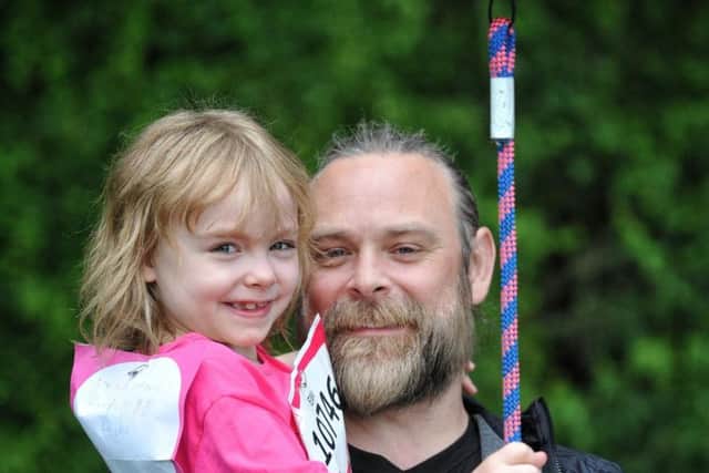 Ellie Rieveley ringing the starter bell at Race For Life with dad Ben